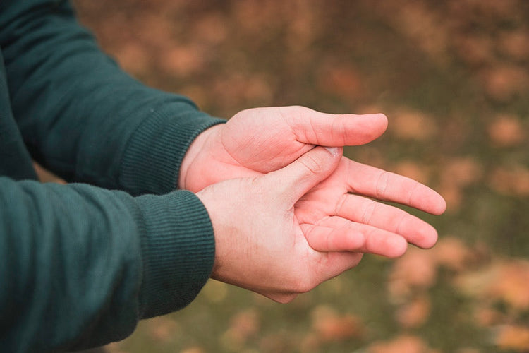 Hands rubbing together in cold weather, highlighting the discomfort of cold hands during outdoor activities, emphasizing the importance of heated gloves in low-temperature environments.