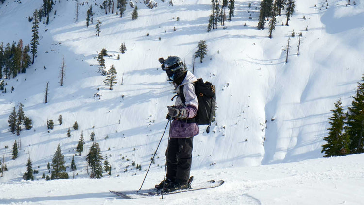A skier wearing a helmet, gloves, and winter gear while skiing down a snowy mountain slope, showcasing winter sports and outdoor adventure
