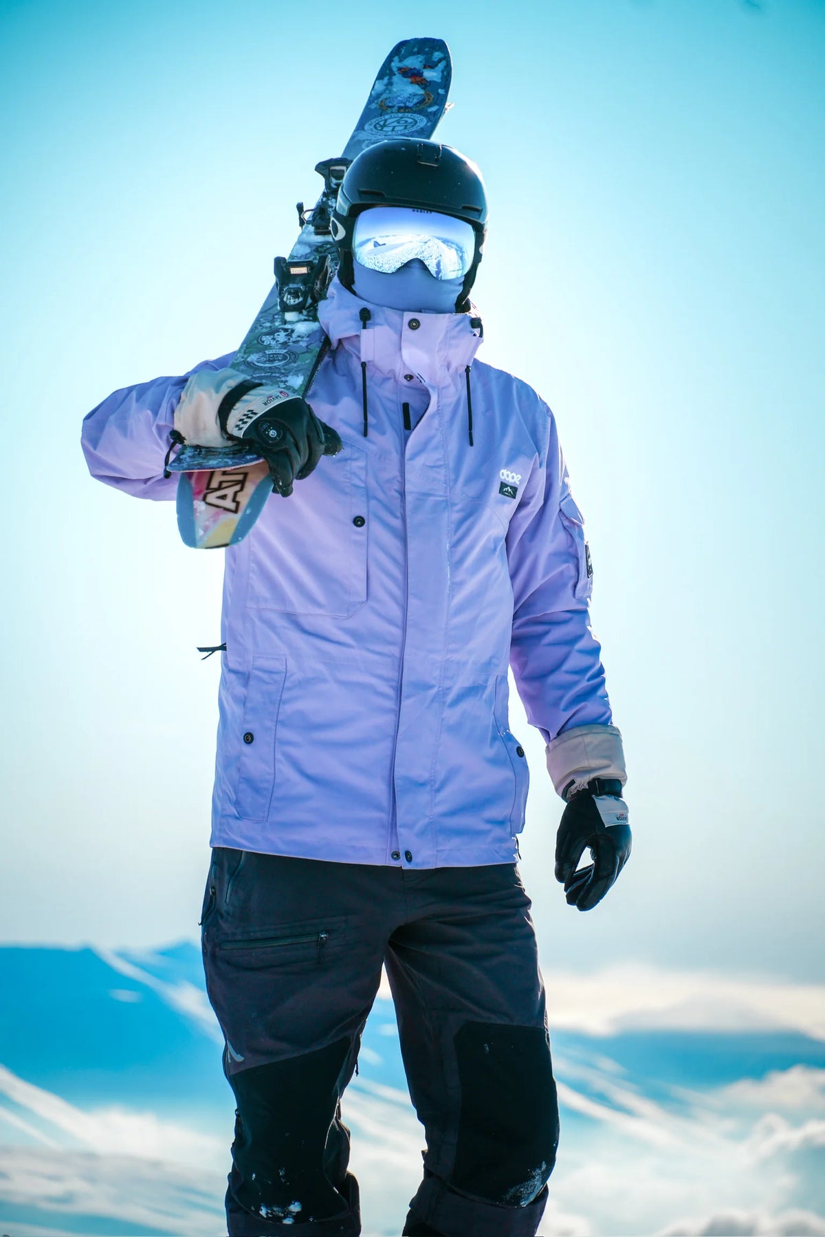 Skier wearing SAVIOR HEAT heated gloves while carrying skis in the mountains